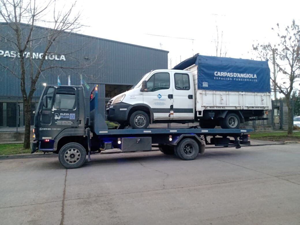 Camión plataforma ELEVAPLUS transportando un vehículo utilitario